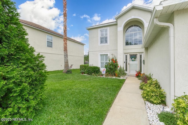 76146 Long Leaf Loop, Yulee, FL 32097 - doorway to property with stucco siding and a yard