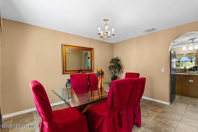 76146 Long Leaf Loop, Yulee, FL 32097 - tiled dining area with arched walkways, a chandelier, and a textured ceiling