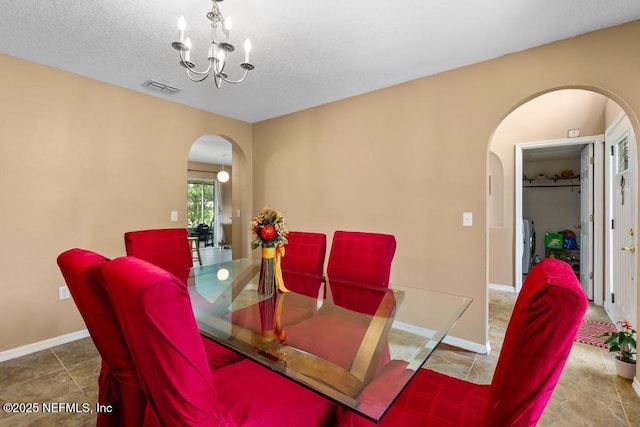 76146 Long Leaf Loop, Yulee, FL 32097 - dining room featuring arched walkways, a chandelier, and a textured ceiling