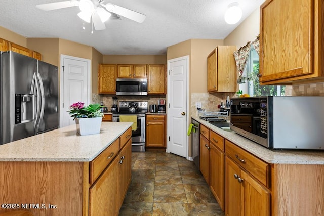 76146 Long Leaf Loop, Yulee, FL 32097 - kitchen with appliances with stainless steel finishes, tasteful backsplash, stone finish floors, a kitchen island, and ceiling fan