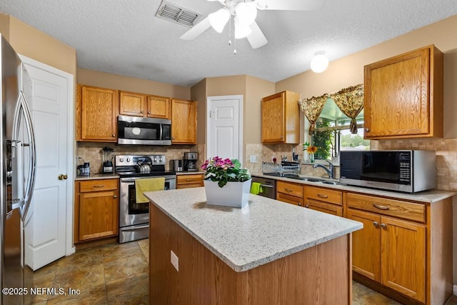 76146 Long Leaf Loop, Yulee, FL 32097 - kitchen featuring stainless steel appliances, backsplash, a kitchen island, ceiling fan, and a textured ceiling
