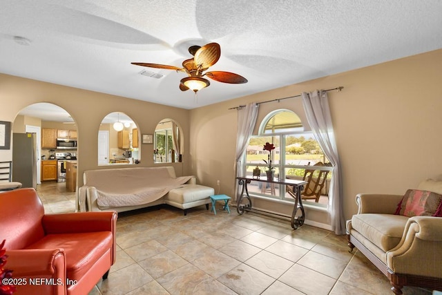 76146 Long Leaf Loop, Yulee, FL 32097 - bedroom featuring freestanding refrigerator, arched walkways, multiple windows, light tile patterned floors, and a textured ceiling