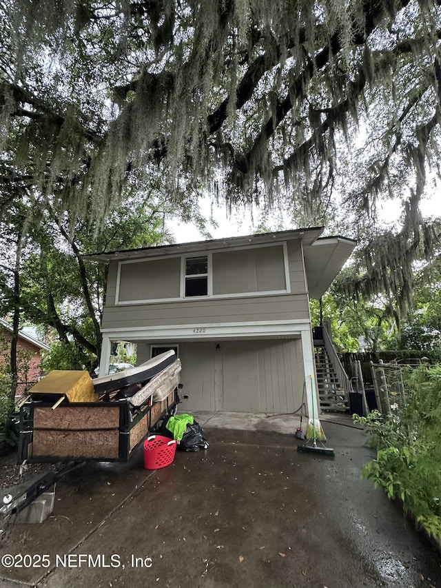 104 W 33rd St, Jacksonville, FL 32206 - view of front facade with stairway, a garage, and driveway