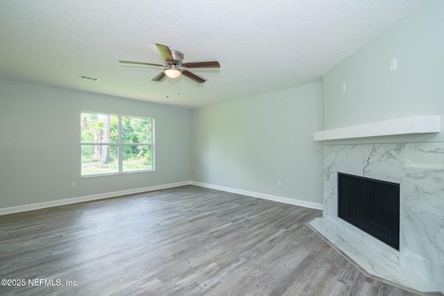 7038 Holiday Hill Ct, Jacksonville, FL 32216 - unfurnished living room with wood finished floors, a ceiling fan, a textured ceiling, and a premium fireplace