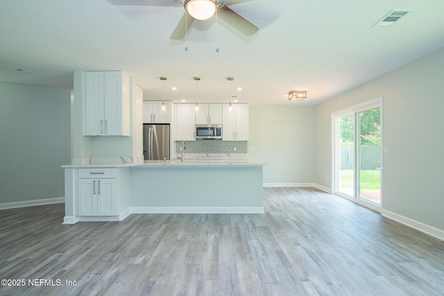 7038 Holiday Hill Ct, Jacksonville, FL 32216 - kitchen with stainless steel appliances, light countertops, white cabinets, and decorative backsplash