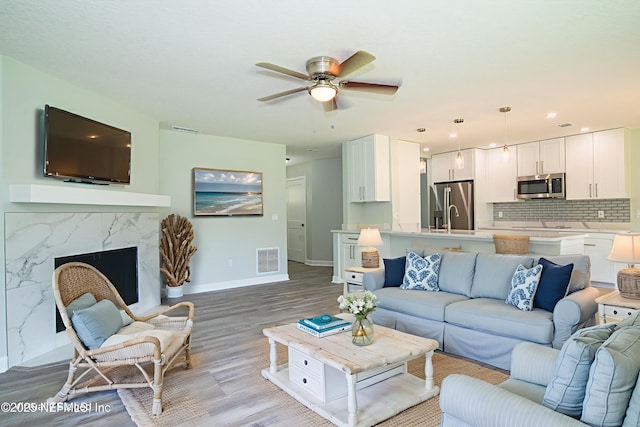7038 Holiday Hill Ct, Jacksonville, FL 32216 - living area featuring light wood-type flooring, a ceiling fan, recessed lighting, and a premium fireplace