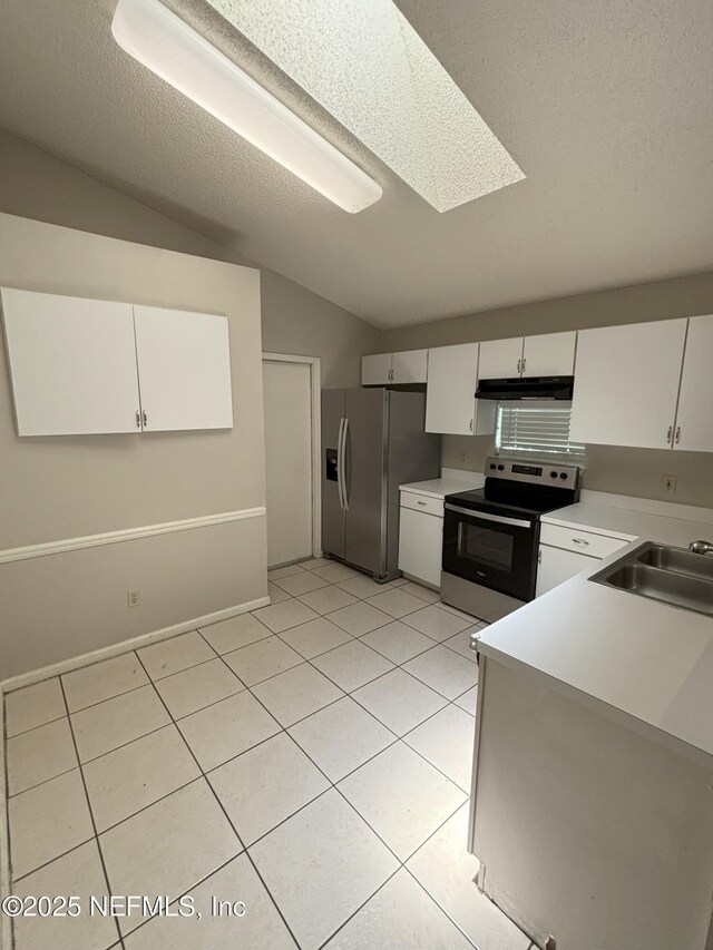 71 Naugatuck Dr, Jacksonville, FL 32225 - kitchen with stainless steel appliances, vaulted ceiling, light countertops, light tile patterned floors, and white cabinets