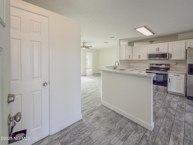 1736 Ashwood Cir, Middleburg, FL 32068 - kitchen with stainless steel appliances, white cabinets, a textured ceiling, light countertops, and wood finish floors