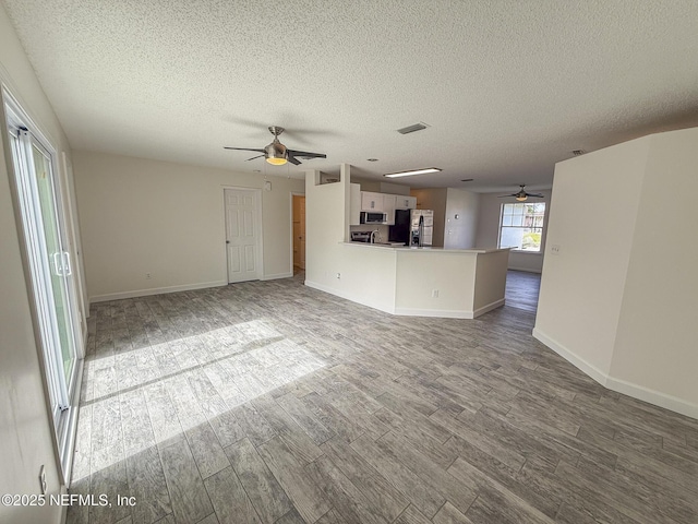 1736 Ashwood Cir, Middleburg, FL 32068 - unfurnished living room featuring ceiling fan, wood finished floors, and a textured ceiling