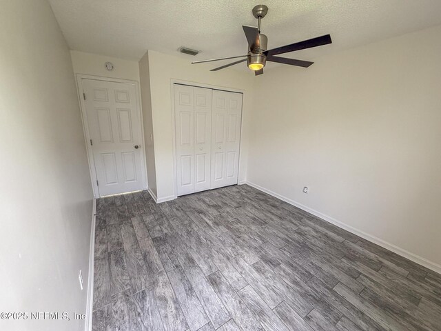 1736 Ashwood Cir, Middleburg, FL 32068 - unfurnished bedroom with dark wood-style floors, a textured ceiling, a closet, and ceiling fan