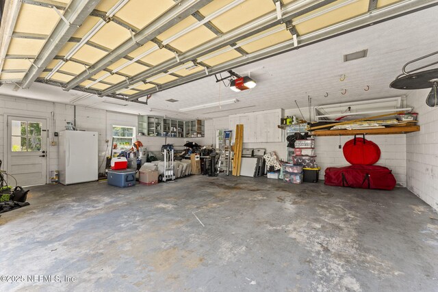 1221 Oriental Gardens Rd, Jacksonville, FL 32207 - garage featuring freestanding refrigerator and a garage door opener