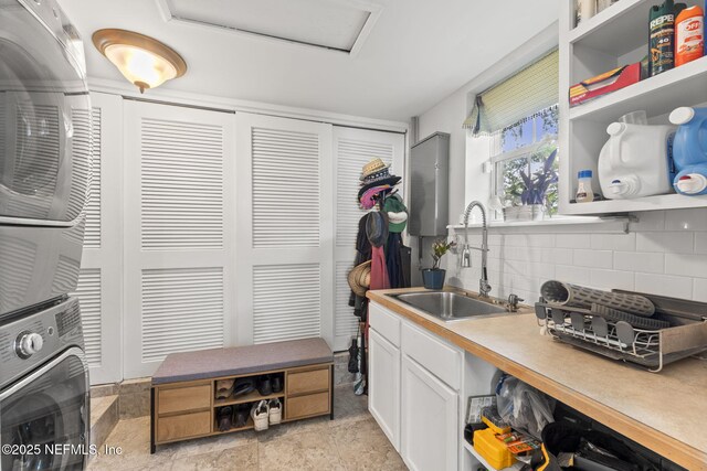 1221 Oriental Gardens Rd, Jacksonville, FL 32207 - kitchen with stacked washer / dryer, open shelves, backsplash, white cabinets, and light countertops