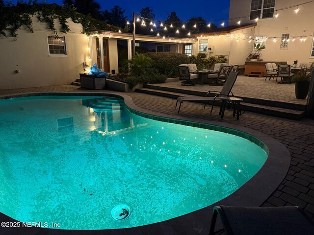 1221 Oriental Gardens Rd, Jacksonville, FL 32207 - pool at night featuring a patio and an outdoor pool