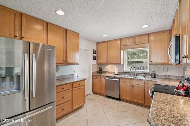 6405 Simca Dr, Jacksonville, FL 32277 - kitchen featuring appliances with stainless steel finishes, decorative backsplash, a textured ceiling, light tile patterned flooring, and brown cabinets