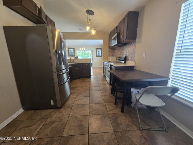 3472 Steelgate Ct, Middleburg, FL 32068 - kitchen featuring stainless steel appliances, tasteful backsplash, hanging light fixtures, dark tile patterned flooring, and a chandelier