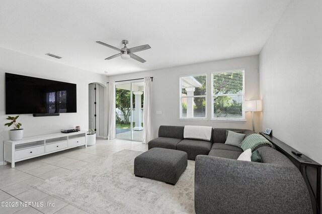 12191 Wynnfield Lakes Cir, Jacksonville, FL 32246 - living area featuring light tile patterned floors, a ceiling fan, and arched walkways