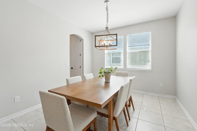 12191 Wynnfield Lakes Cir, Jacksonville, FL 32246 - dining room with arched walkways, a chandelier, and light tile patterned flooring