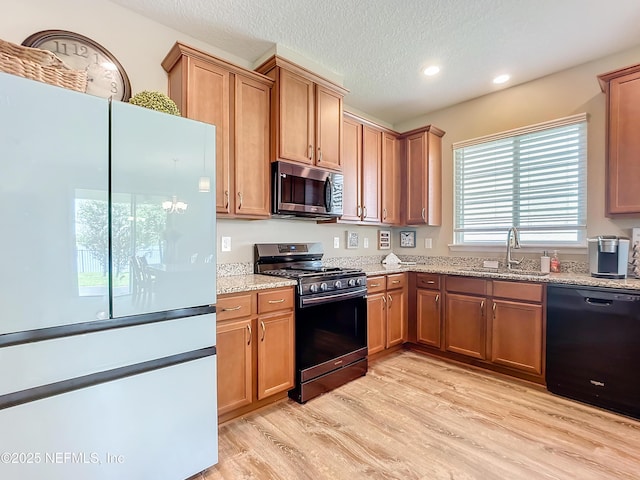 132 Yellowfin Dr, Saint Augustine, FL 32095 - kitchen featuring freestanding refrigerator, range with gas stovetop, stainless steel microwave, black dishwasher, and light wood-style floors