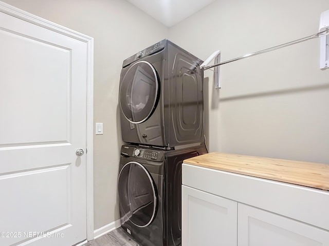 132 Yellowfin Dr, Saint Augustine, FL 32095 - laundry room featuring estacked washer and dryer, cabinet space, and light wood-style floors