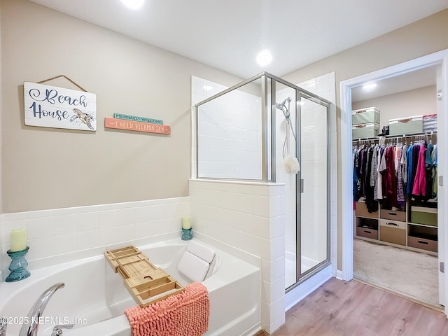 132 Yellowfin Dr, Saint Augustine, FL 32095 - full bathroom with a bath, a walk in closet, a shower stall, and wood finished floors