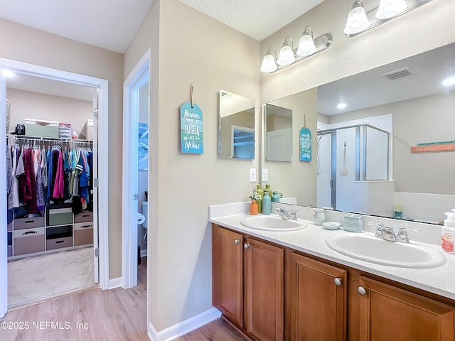 132 Yellowfin Dr, Saint Augustine, FL 32095 - bathroom featuring wood finished floors, a shower stall, a spacious closet, and double vanity