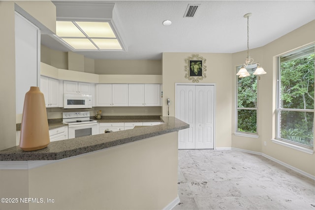 6992 Tonga Dr, Jacksonville, FL 32216 - kitchen with white appliances, a peninsula, white cabinets, a chandelier, and decorative light fixtures