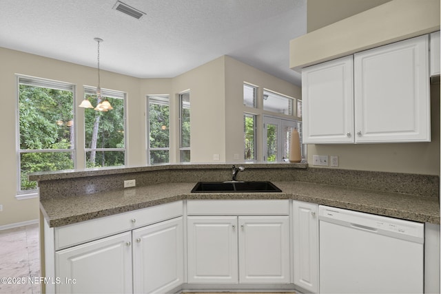 6992 Tonga Dr, Jacksonville, FL 32216 - kitchen with white dishwasher, a peninsula, white cabinetry, pendant lighting, and a textured ceiling