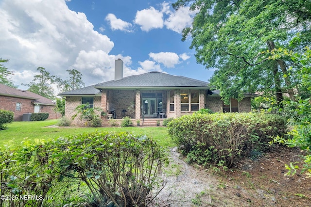 6992 Tonga Dr, Jacksonville, FL 32216 - rear view of property featuring brick siding, a chimney, and a yard
