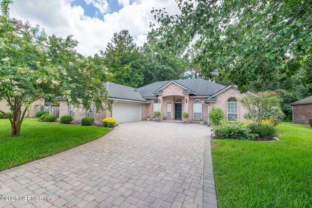 6992 Tonga Dr, Jacksonville, FL 32216 - ranch-style home with an attached garage, driveway, brick siding, and a front lawn