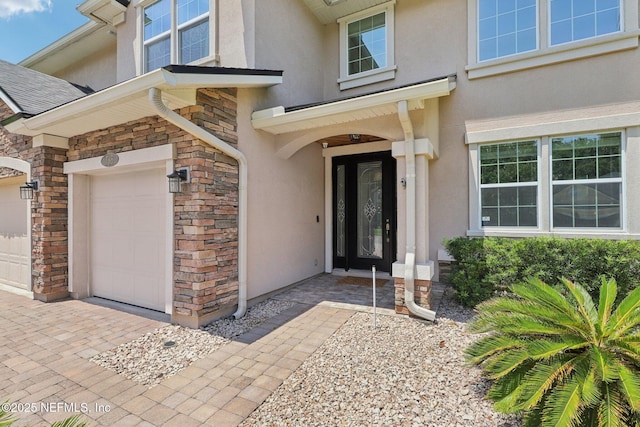 738 W Kings College Dr, Fruit Cove, FL 32259 - property entrance with stucco siding, stone siding, and a garage
