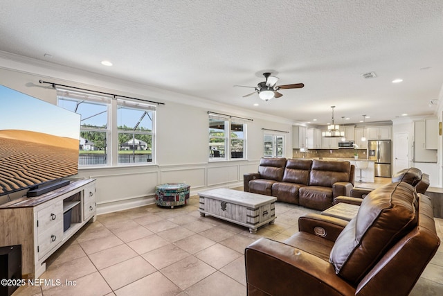 738 W Kings College Dr, Fruit Cove, FL 32259 - living room featuring a ceiling fan, ornamental molding, light tile patterned flooring, recessed lighting, and a wainscoted wall