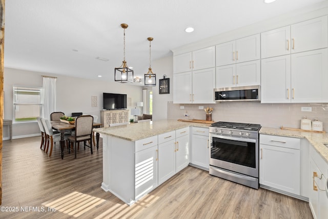 111 Beam Ln, Saint Augustine, FL 32095 - kitchen with appliances with stainless steel finishes, a peninsula, plenty of natural light, white cabinetry, and recessed lighting