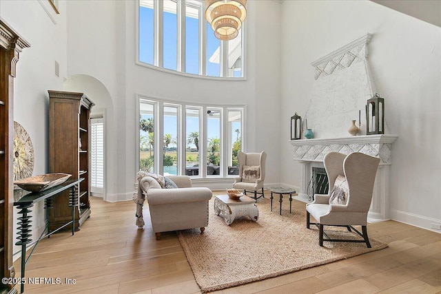 24736 Harbour View Dr, Ponte Vedra Beach, FL 32082 - living room featuring a high ceiling, hardwood / wood-style floors, a fireplace with raised hearth, and arched walkways