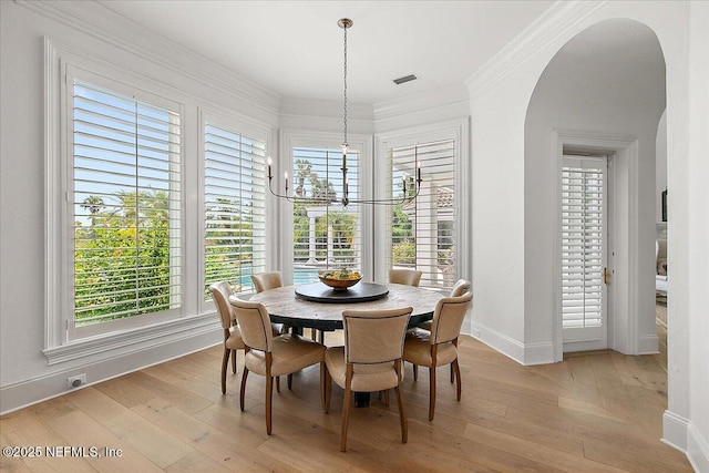 24736 Harbour View Dr, Ponte Vedra Beach, FL 32082 - dining area featuring arched walkways, a chandelier, light wood-style flooring, and ornamental molding