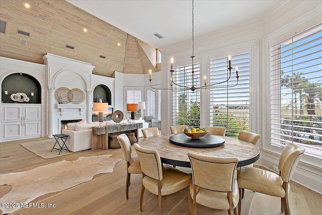 24736 Harbour View Dr, Ponte Vedra Beach, FL 32082 - dining room with a chandelier, a towering ceiling, light wood-type flooring, and a fireplace