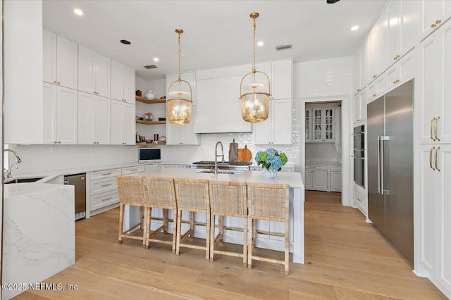 24736 Harbour View Dr, Ponte Vedra Beach, FL 32082 - kitchen featuring stainless steel appliances, decorative backsplash, light wood-style floors, open shelves, and a kitchen breakfast bar