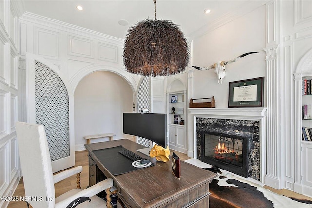 24736 Harbour View Dr, Ponte Vedra Beach, FL 32082 - office with a premium fireplace, built in shelves, arched walkways, wood finished floors, and recessed lighting