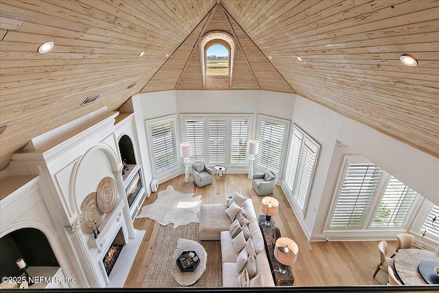 24736 Harbour View Dr, Ponte Vedra Beach, FL 32082 - living area featuring wood ceiling, high vaulted ceiling, healthy amount of natural light, a glass covered fireplace, and wood finished floors