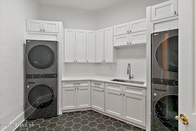 24736 Harbour View Dr, Ponte Vedra Beach, FL 32082 - laundry room featuring stacked washing machine and dryer, cabinet space, and dark tile patterned floors