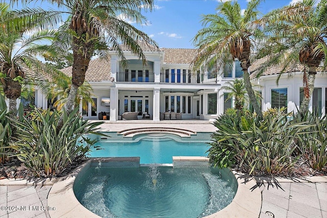 24736 Harbour View Dr, Ponte Vedra Beach, FL 32082 - back of house featuring a balcony, a pool with connected hot tub, a tiled roof, a patio, and stucco siding