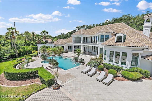 24736 Harbour View Dr, Ponte Vedra Beach, FL 32082 - back of property featuring a balcony, a patio, a tiled roof, stucco siding, and an outdoor pool