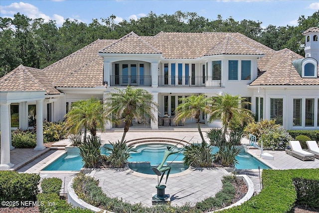 24736 Harbour View Dr, Ponte Vedra Beach, FL 32082 - back of property with a balcony, a tile roof, a patio, a pool with connected hot tub, and stucco siding