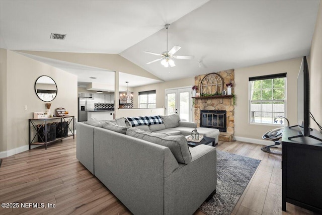 2168 Minorcan St, Middleburg, FL 32068 - living area with lofted ceiling, a fireplace, ceiling fan, light wood finished floors, and a chandelier