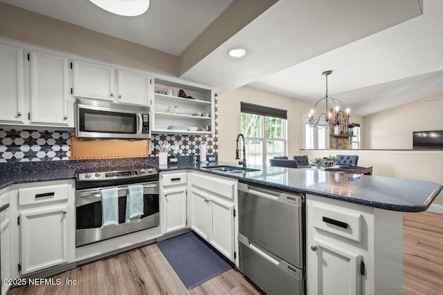 2168 Minorcan St, Middleburg, FL 32068 - kitchen with stainless steel appliances, a peninsula, white cabinetry, light wood finished floors, and recessed lighting
