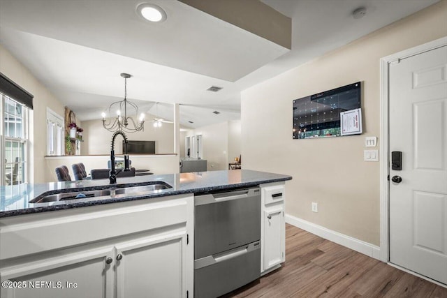 2168 Minorcan St, Middleburg, FL 32068 - kitchen featuring dishwasher, white cabinets, wood finished floors, dark stone countertops, and a chandelier