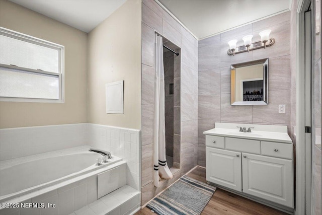 2168 Minorcan St, Middleburg, FL 32068 - full bath with vanity, a bath, a stall shower, wood finished floors, and tile walls