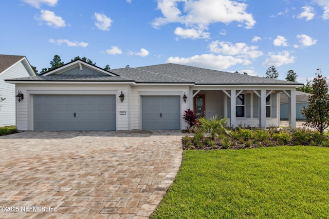 613 Witty Banter Ct, Yulee, FL 32097 - single story home with an attached garage, a front yard, decorative driveway, roof with shingles, and a porch