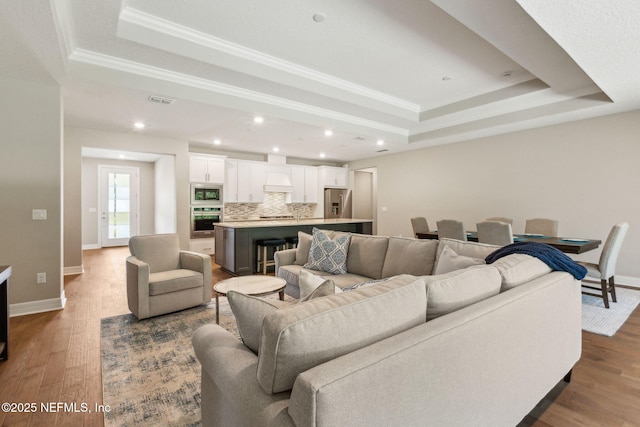 613 Witty Banter Ct, Yulee, FL 32097 - living room featuring a raised ceiling, ornamental molding, dark wood finished floors, and recessed lighting