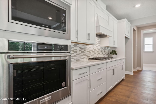 613 Witty Banter Ct, Yulee, FL 32097 - kitchen with appliances with stainless steel finishes, light countertops, backsplash, white cabinets, and dark wood-type flooring