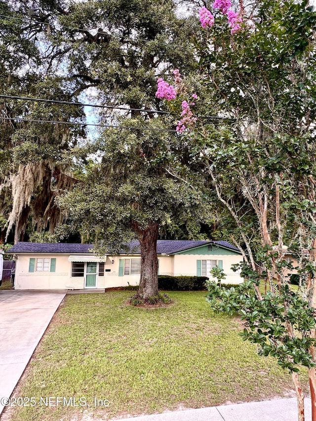 457 Nightingale Rd, Jacksonville, FL 32216 - ranch-style house featuring a front lawn, stucco siding, and driveway